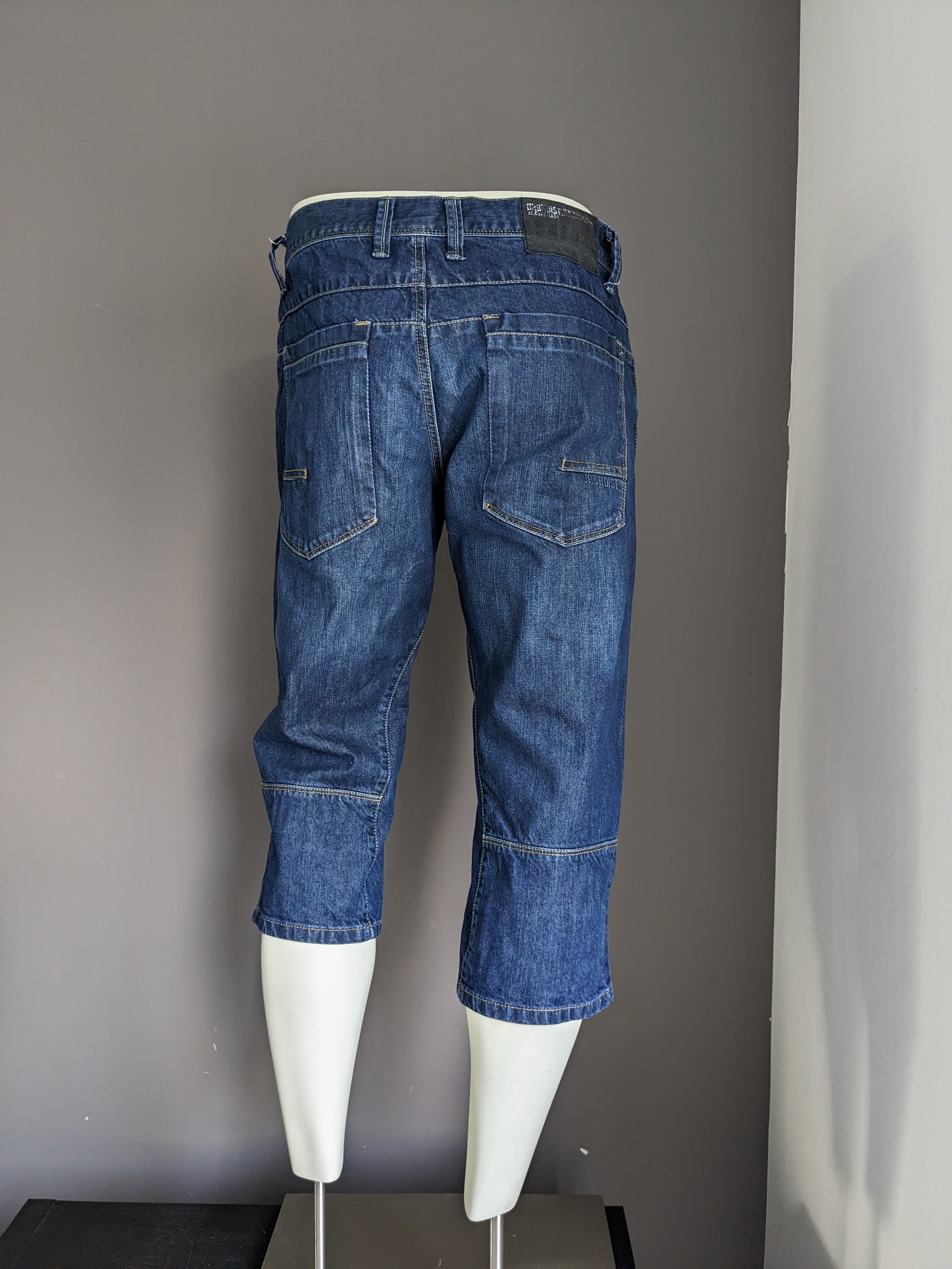 Urban district 3/4th shorts of jeans fabric. Dark blue colored