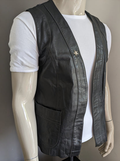 Leren gilet zonder sluiting. Zwart gekleurd met zilverkleurige ster. Maat M / L.