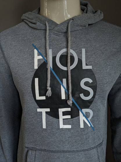 Hollister Hoodie. Donker Grijs gemêleerd met opdruk. Maat M.