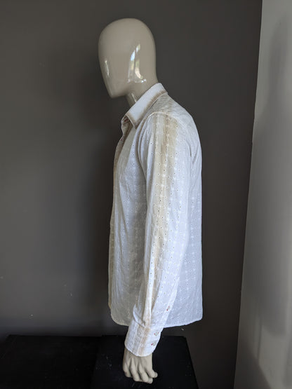 Es una camisa Noize. Motifa de agujeros beige blanco. Tamaño xl.