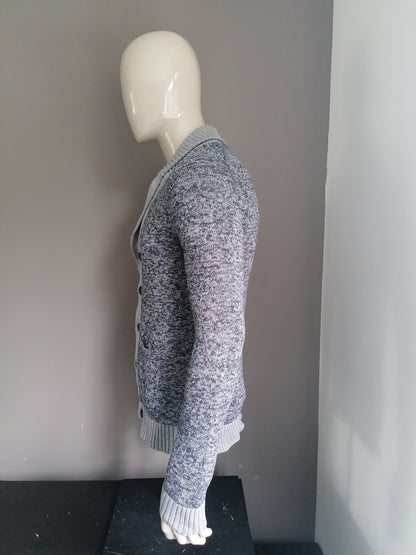 Nous façonnons le cardigan avec des boutons. Gris bleu mélangé. Taille M.