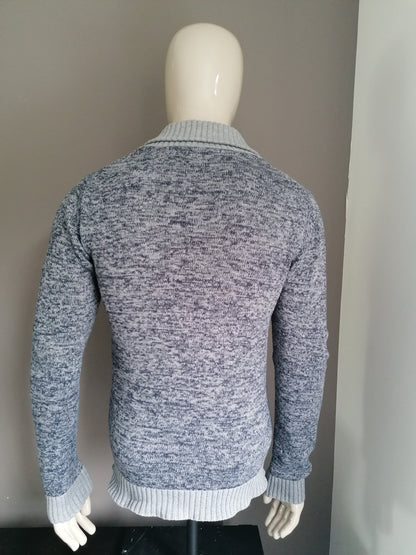 Nous façonnons le cardigan avec des boutons. Gris bleu mélangé. Taille M.