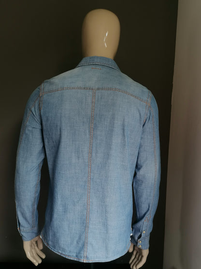 Rempille jeans / chemise en jean avec goujons de presse. Couleur bleue. Taille L.